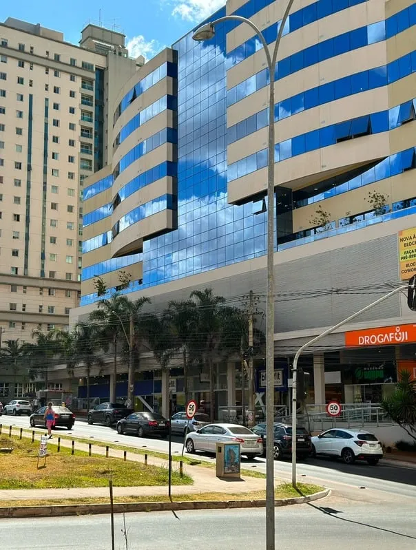 Fachada do Edifício Cosmopolitan em Águas Claras, prédio espelhado em azul onde fica a Baby Kids, com a Academia Blue Fit no térreo
